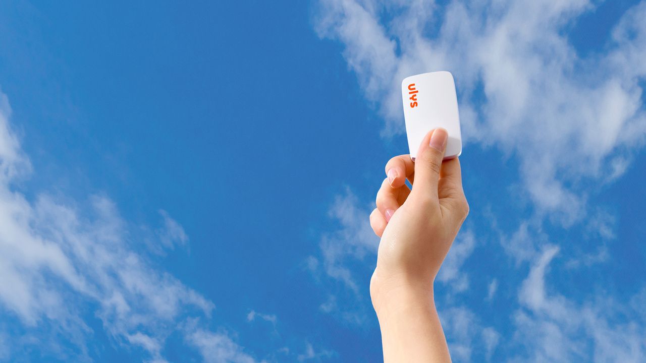 main qui tend le badge sur fond ciel bleu